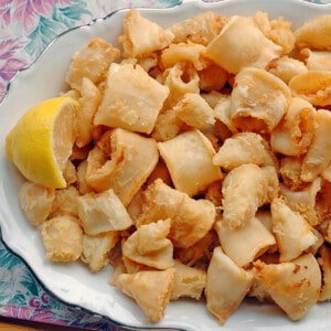 prepared calamari on a platter with a lemon wedge