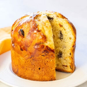baked panettone on a plate with a slice cut out