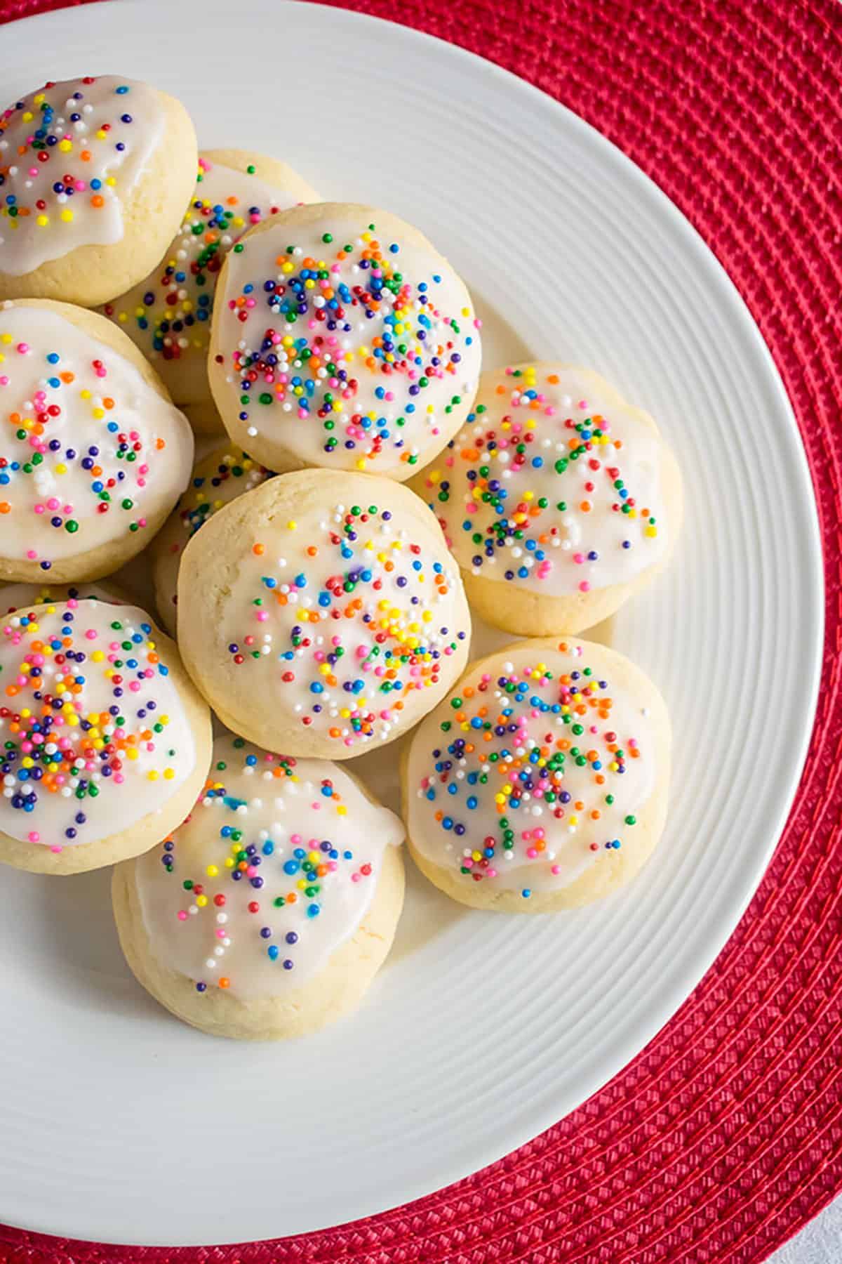 plate of italian cookies with glaze and rainbow sprinkles