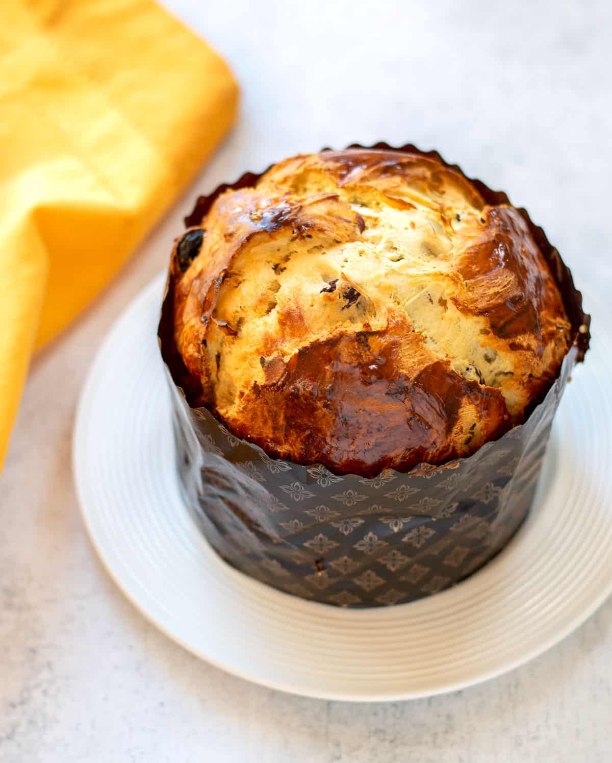 baked panettone in a paper mold on a plate