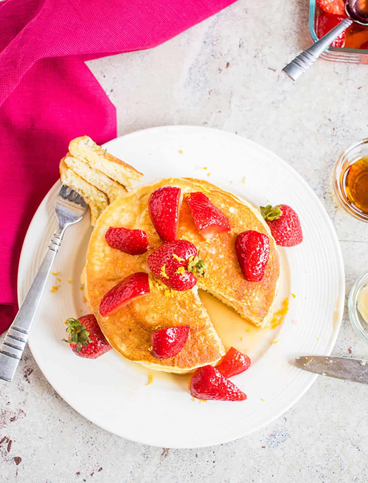 stack of pancakes on a plate garnished with strawberries