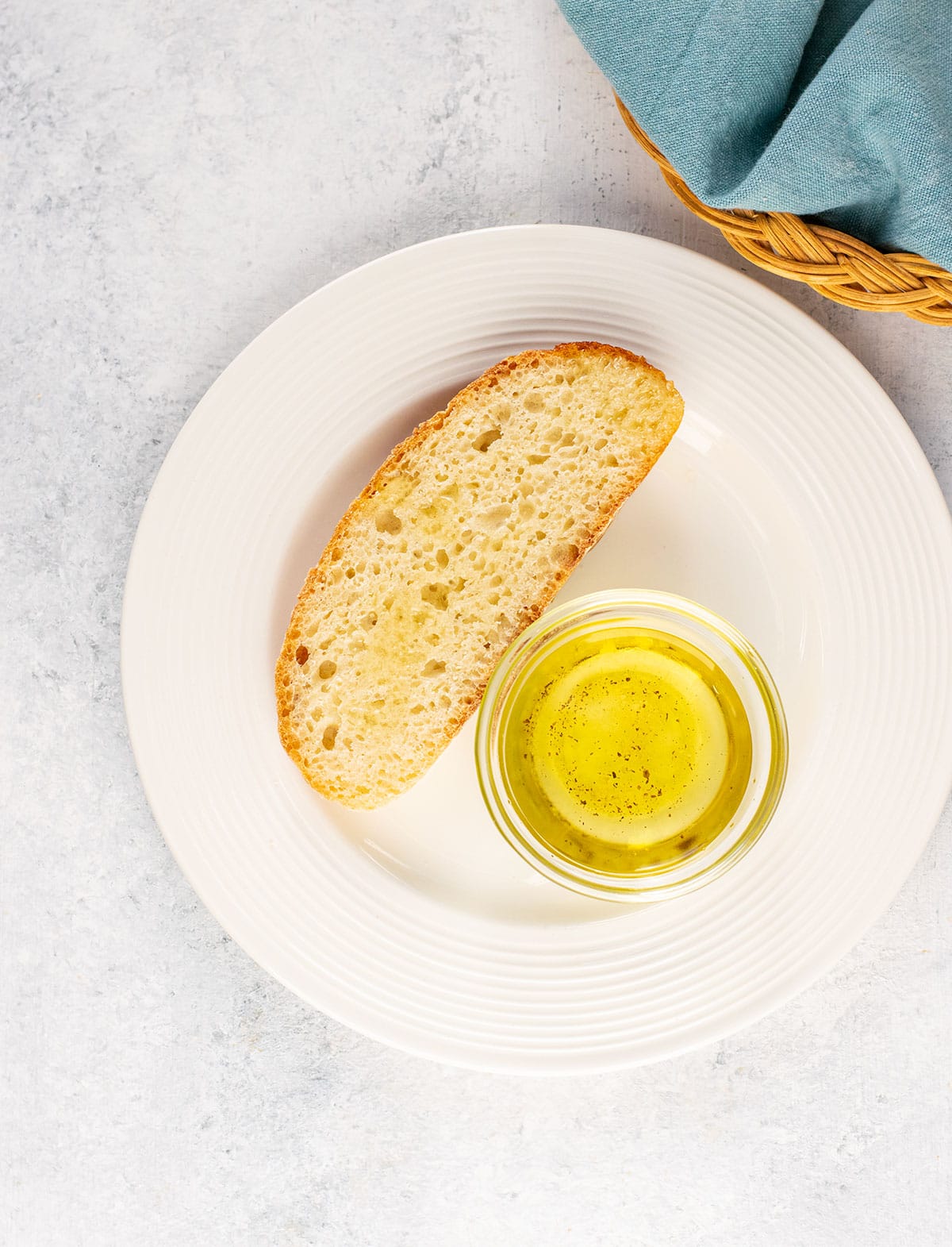 slice of italian bread on a plate with a cup of seasoned oil
