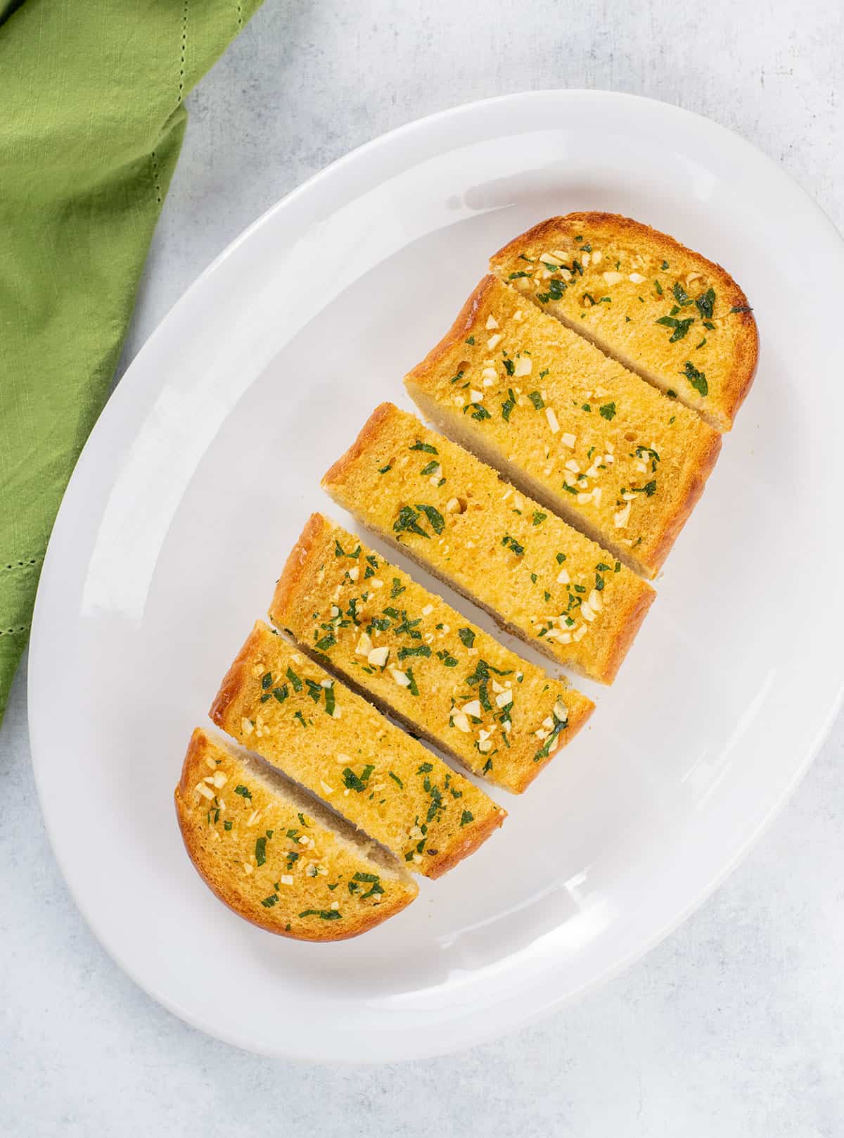 loaf of garlic bread made from italian bread on a platter