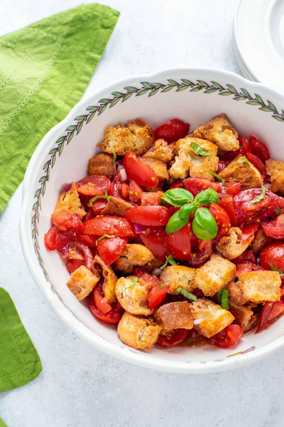 bowl of bread and tomato salad garnished with basil leaves