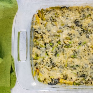 glass pan of baked risotto with asparagus and spinach