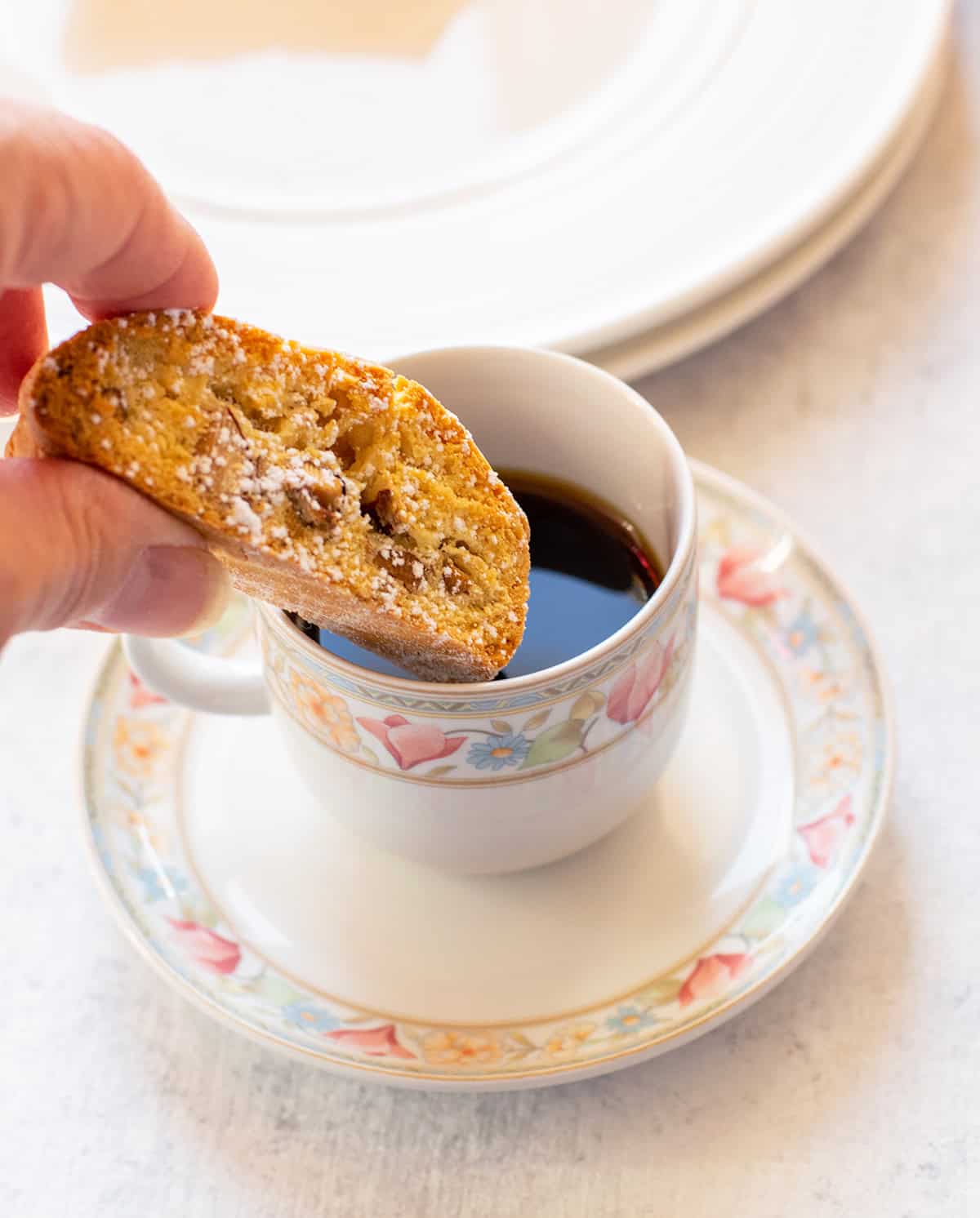 almond biscotti being dunked into espresso