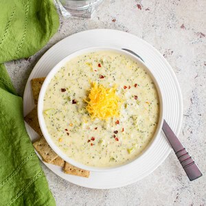 overhead bowl of broccoli cheddar soup topped with cheddar cheese
