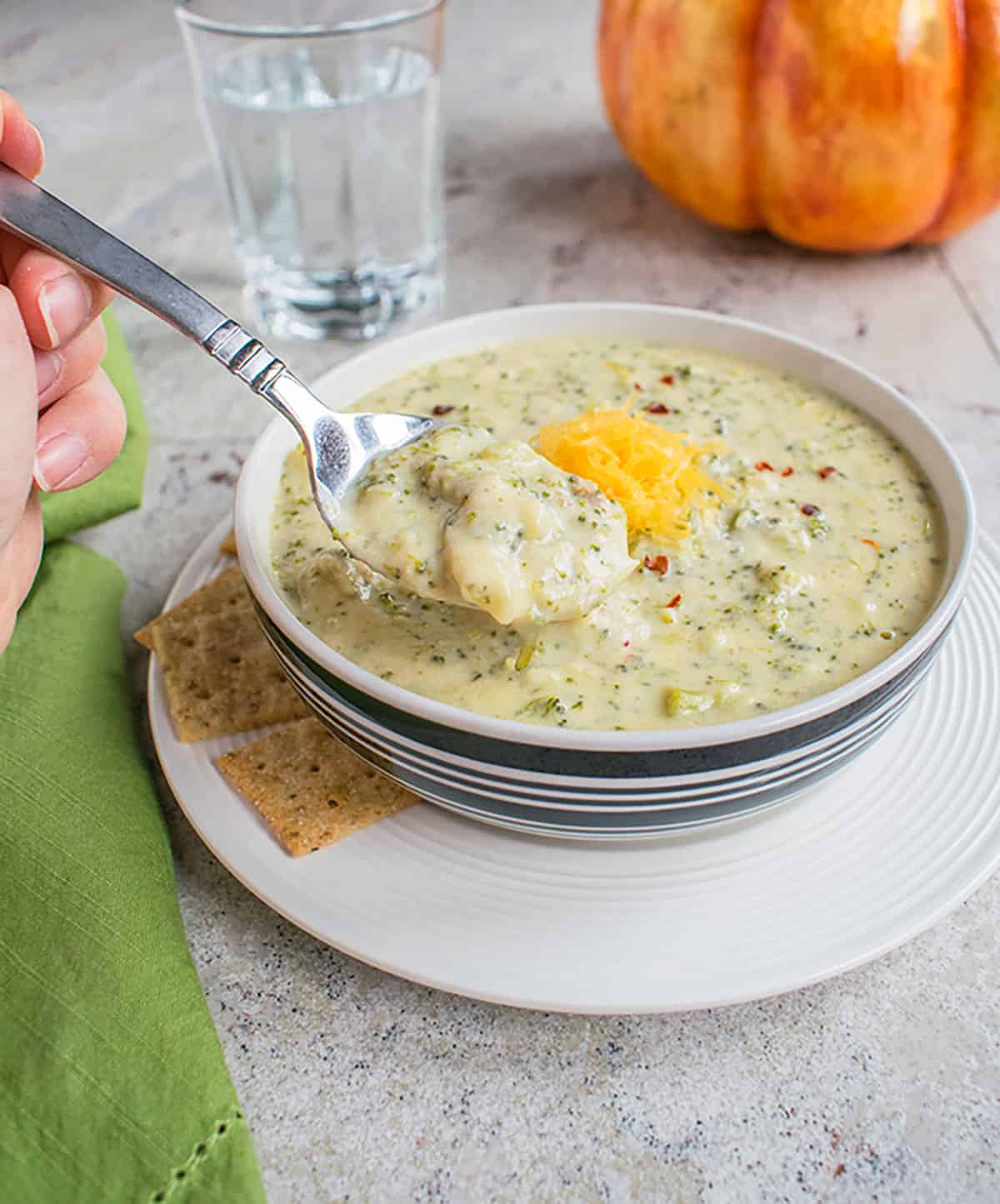 bowl of broccoli cheddar soup with a spoonful