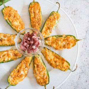 platter of stuffed jalapeño poppers with bowl of prosciutto