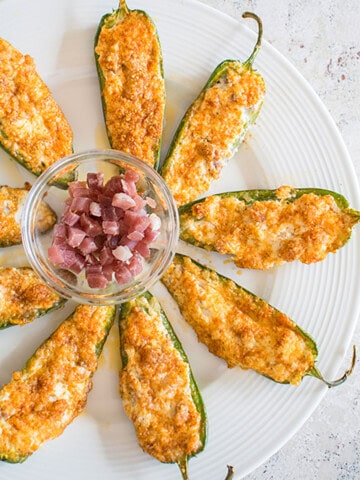platter of stuffed jalapeño poppers with bowl of prosciutto