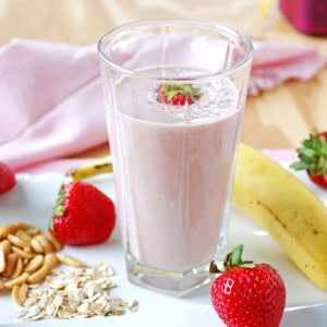 peanut butter and jelly smoothie in a glass with strawberries