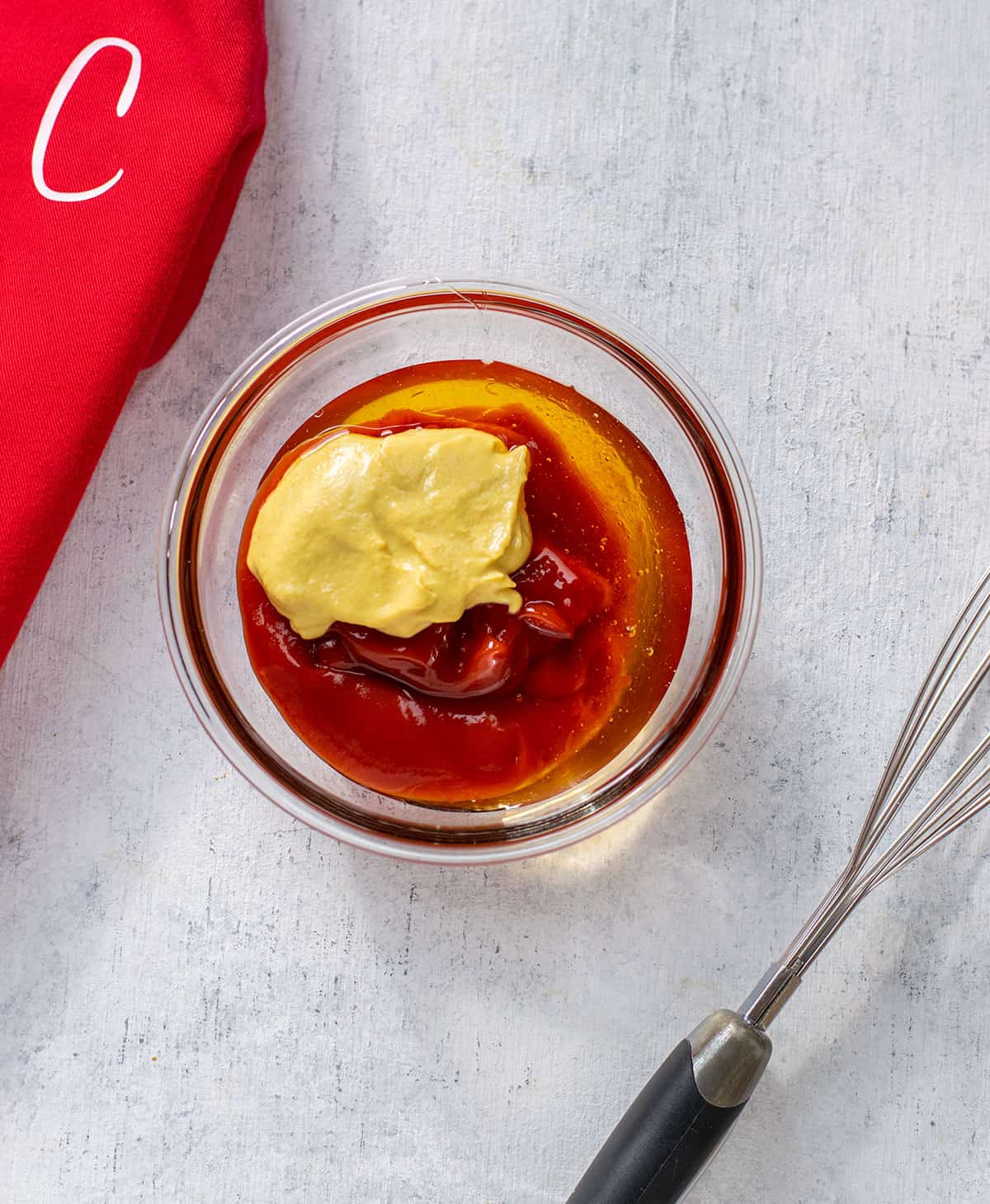 ketchup, mustard and honey in glass bowl with whisk