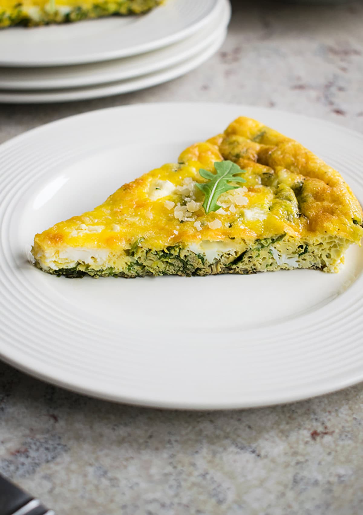 slice of arugula frittata on a plate