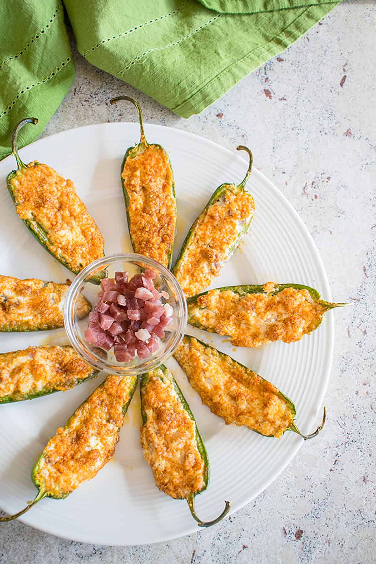 platter of stuffed jalapeño poppers with bowl of prosciutto