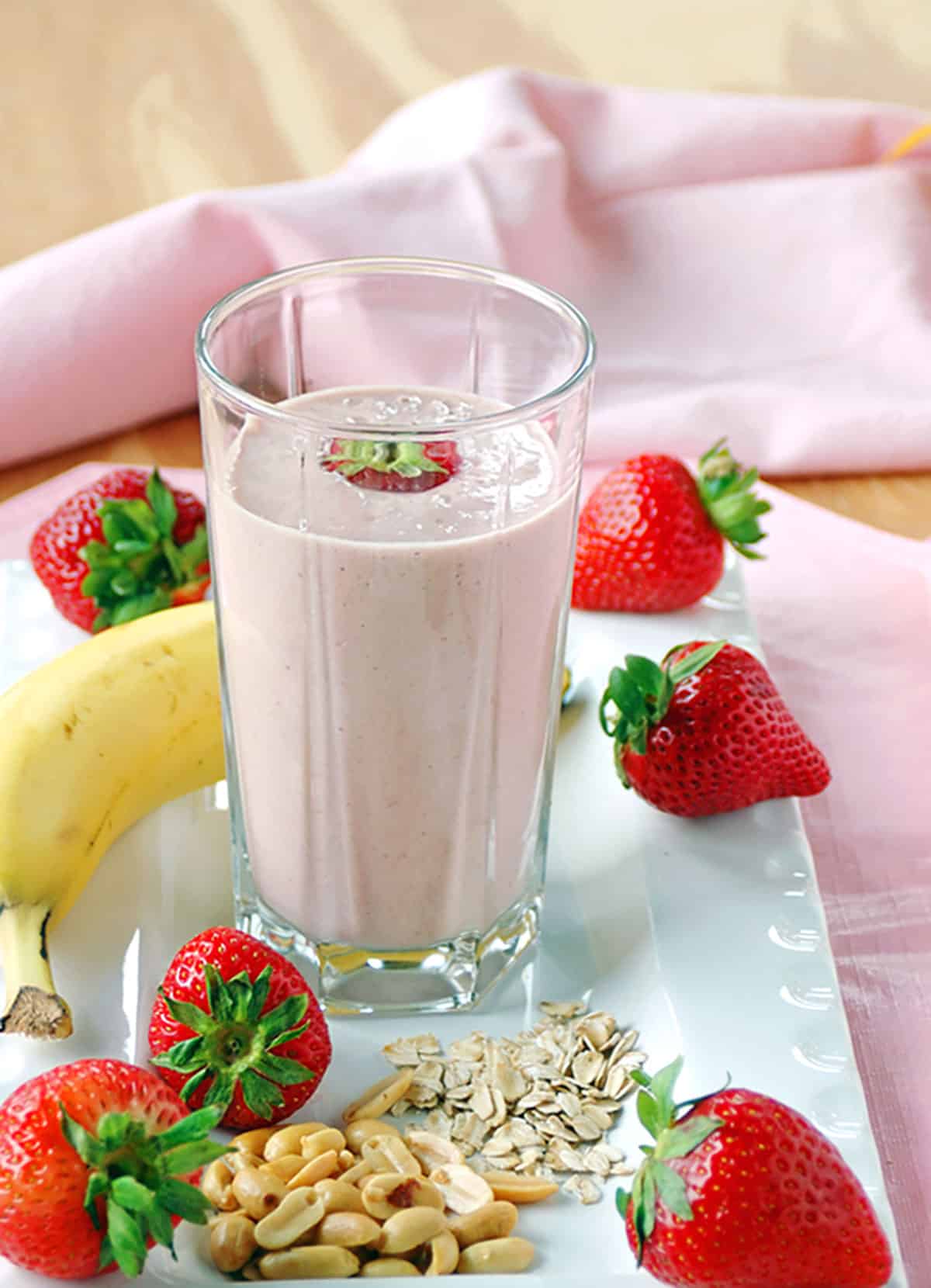 peanut butter and jelly smoothie in a glass with strawberries