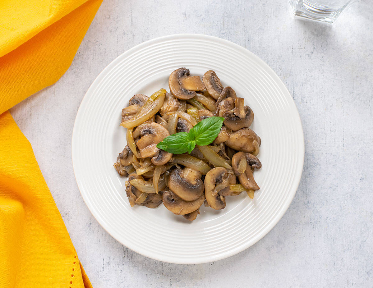 plate of sautéed mushrooms and onions garnished with basil
