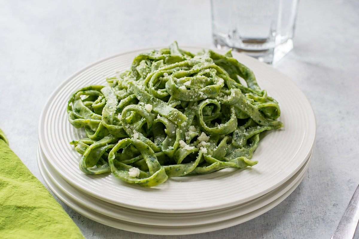 plate of homemade spinach fettuccine topped with cheese