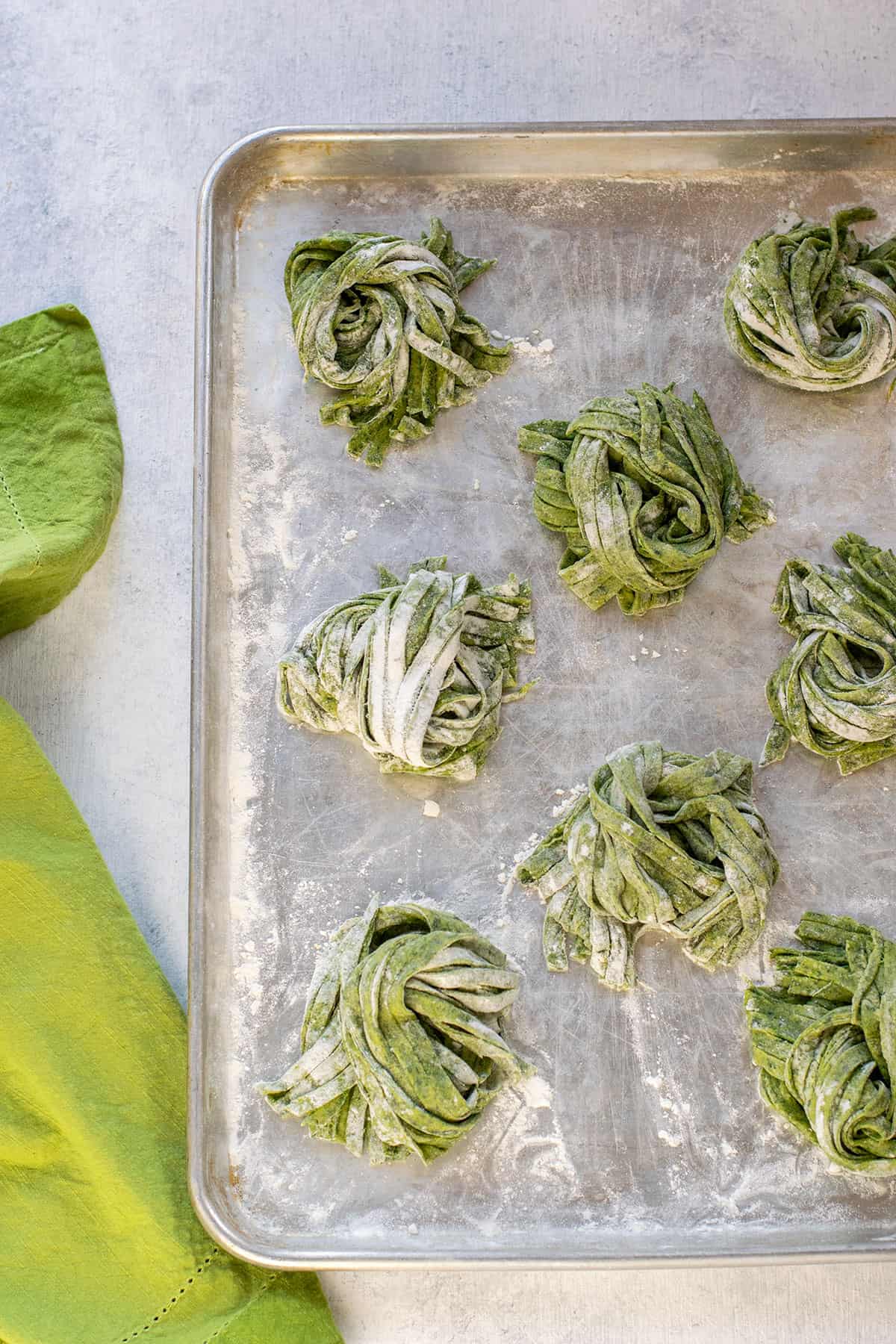 tray with piles of raw homemade spinach fettuccine
