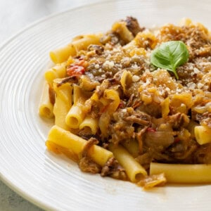 plate of ziti topped with Genovese sauce and basil