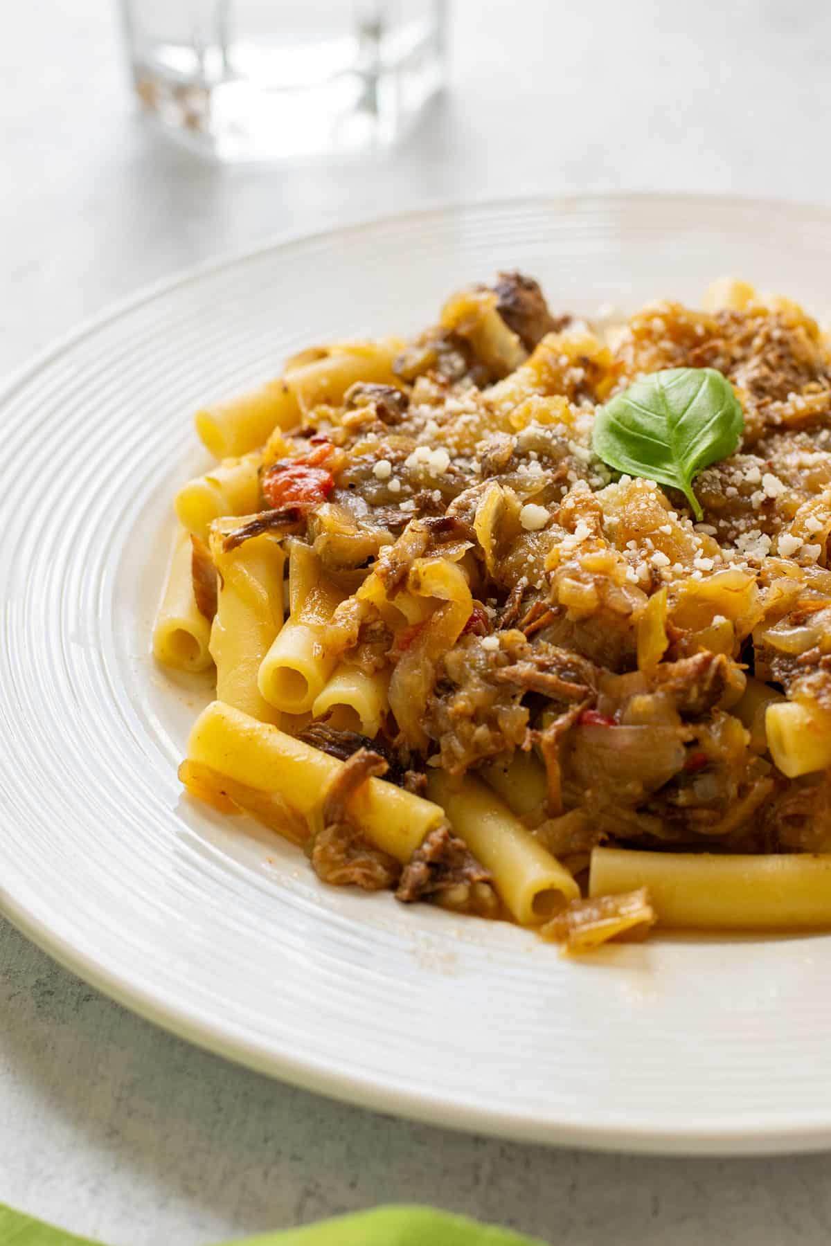 plate of ziti topped with Genovese sauce and basil