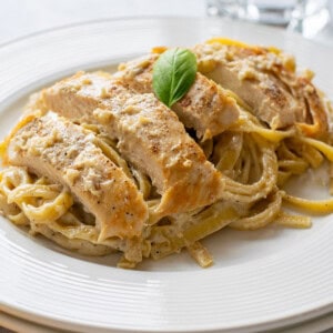 plate of chicken alfredo with fettuccine and basil