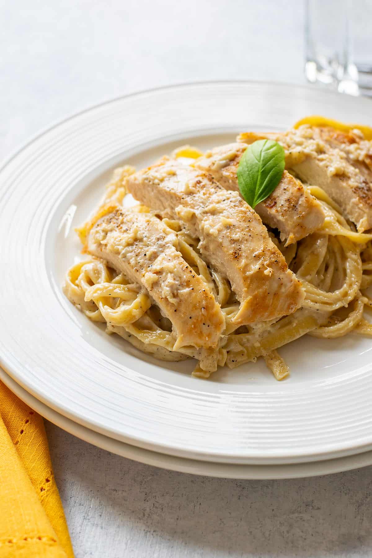 plate of chicken alfredo with fettuccine and basil
